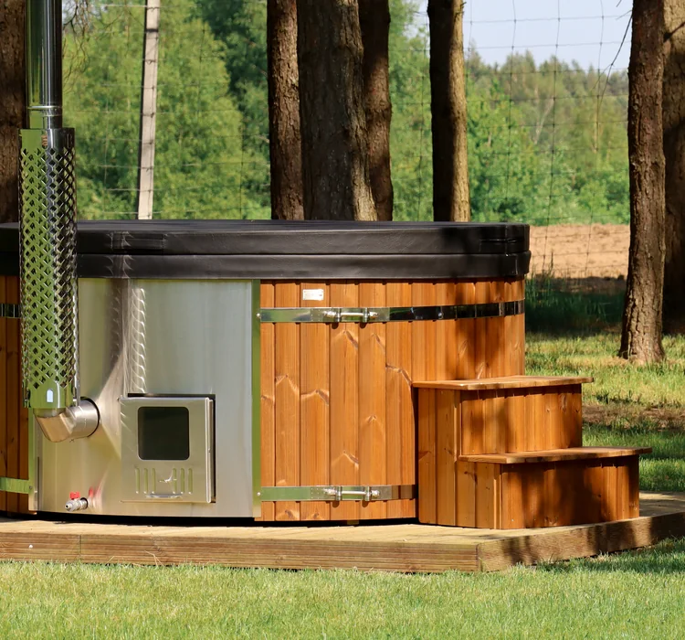 Thermowood-clad hot tub with steps in a woodland setting
