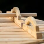 Close-up of wooden toy train tracks with curved pieces on a light wooden surface.