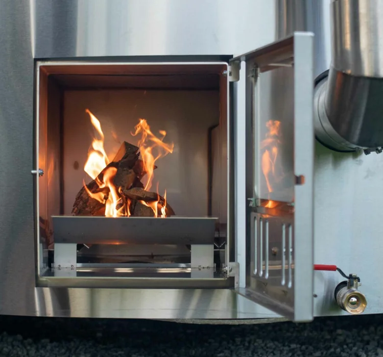 Stainless steel wood-burning stove with the door open and a fire inside